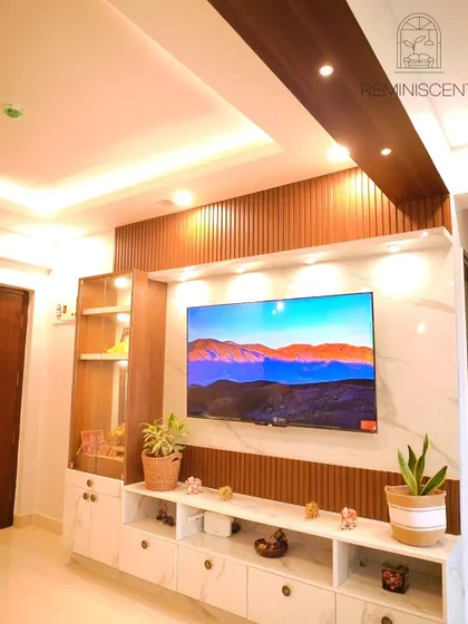 A grand TV unit that combines a marble-finish back panel with dark wood rafters and a glass display case. The integrated lighting creates a warm and luxurious feel.