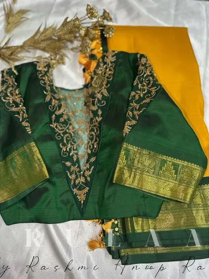 A beautiful green blouse with a sheer yoke and bell sleeves. The neckline is embroidered with delicate zardosi work, creating an elegant and sophisticated look.