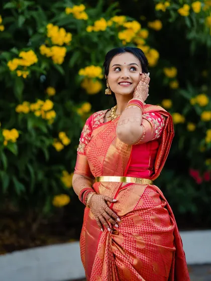 A beautiful bridal portrait of Devika, looking up with a dreamy expression against a backdrop of yellow flowers.