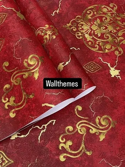 A close-up of a vibrant red wallpaper with an ornate gold damask pattern.