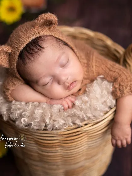 A sleepy little bear cub nestled in a basket in an enchanted forest. This theme combines nature and fantasy for a truly magical newborn portrait.