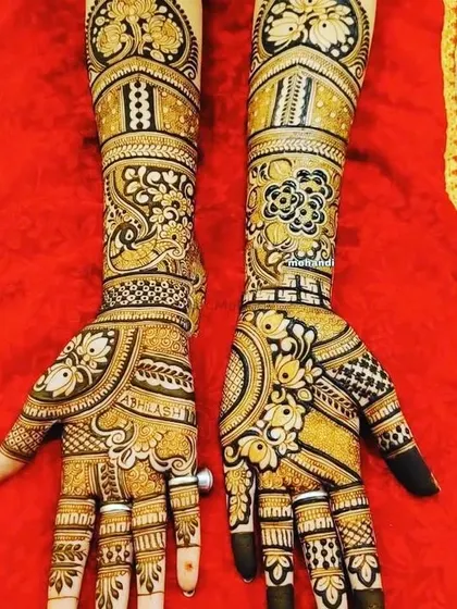 A gorgeous design featuring peacocks and floral patterns with bold shading. The dark fingertips are a classic part of bridal mehndi.