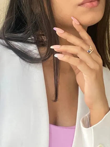 A subtle yet stylish look. This client is wearing a custom set of press-on nails featuring a delicate pastel-colored French tip, perfect for a chic and professional vibe.
