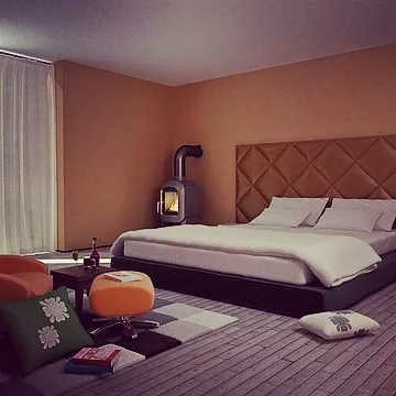A bedroom painted in a cozy, muted orange tone. The warm color creates an intimate and relaxing atmosphere, perfect for a personal retreat.
