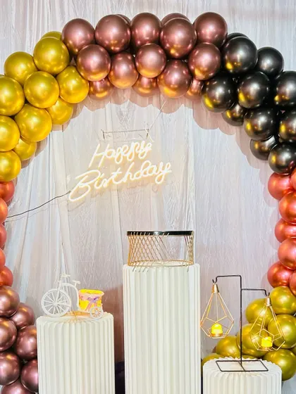 A close-up view of the multi-colored chrome balloon arch. The blend of different metallic shades gives the decoration a rich and festive look.