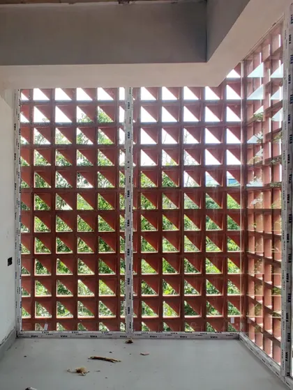 From the inside, the terracotta screen frames views of the outdoors while filtering the sunlight, creating interesting patterns within the office space.
