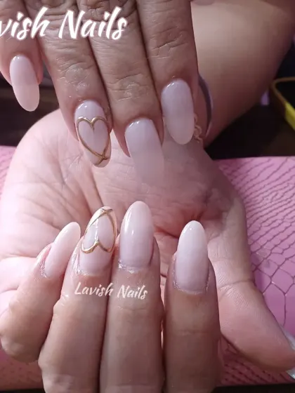 An elegant and minimalist design with a sheer pink base and a single, delicate gold heart outline on an accent nail.