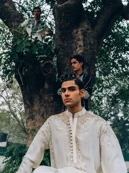 An outdoor editorial for menswear designer Sanchit Sharma. The composition uses the natural environment, with models placed within a tree to create a unique, layered image.