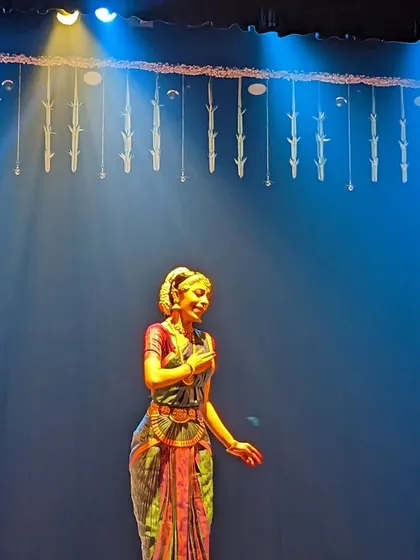 A moment of gratitude on stage at the end of a performance. The simple blue lighting and stage decor create a serene and beautiful atmosphere.