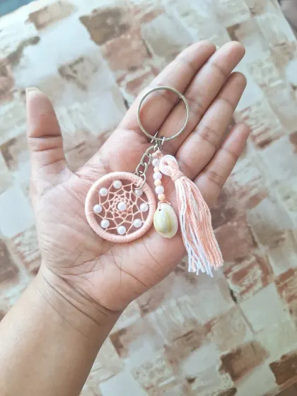 Our shell dreamcatcher keychain in a soft peach color. It's a little piece of magic to carry with you, perfect as a small gift or personal accessory.