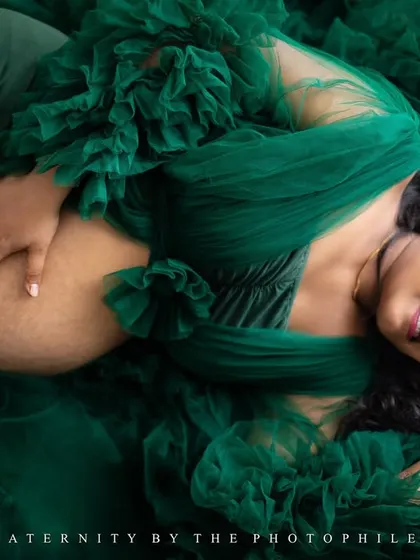 An artistic overhead shot, with the mom-to-be lying in a sea of green tulle, creating a breathtaking and unique image.