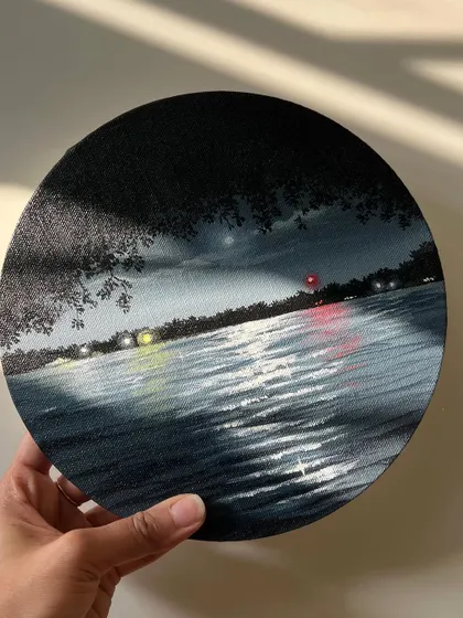 Holding the finished round nightscape painting.