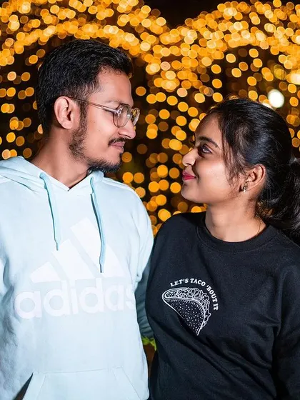 A romantic portrait of a couple framed within a heart-shaped light installation.