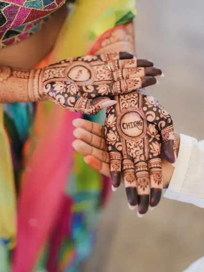 A close-up of the bride's hands adorned with intricate henna, with the groom's name beautifully hidden in the design. It's these small, personal details that make your day unique.