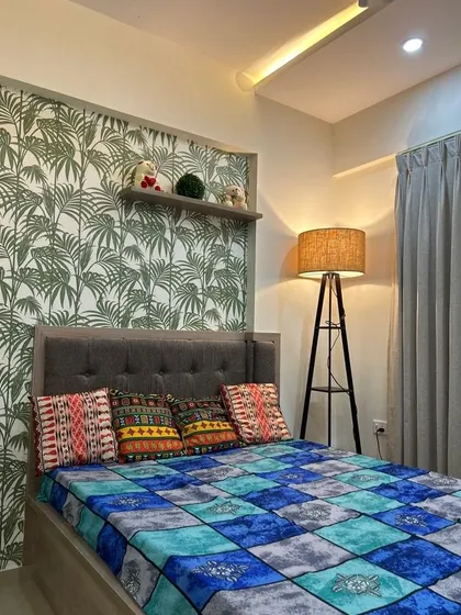 Transform your bedroom into a tropical paradise with this lush palm leaf wallpaper. Paired with a simple grey headboard and a rustic floor lamp, it creates a serene and relaxing escape.