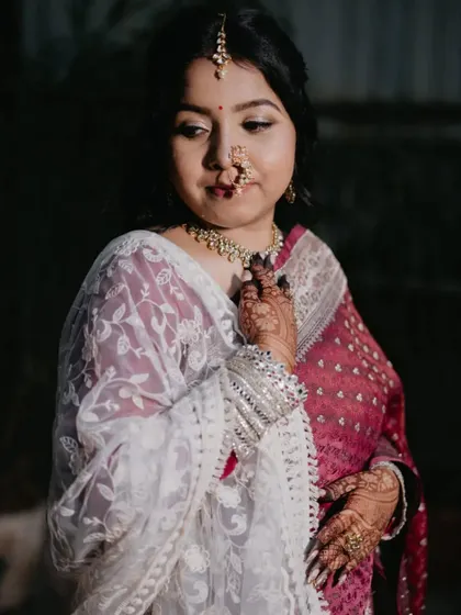 A beautiful portrait of the bride, looking down at her nath. The makeup is understated, allowing the traditional elements to stand out.