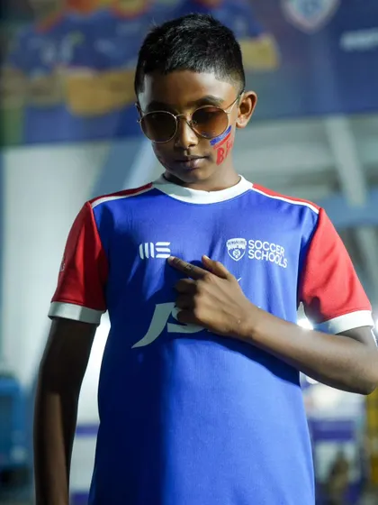 Pointing to the badge with pride. This young fan is ready to cheer on the Blues.