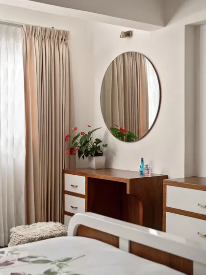 The sleek dressing table with a large circular mirror in the master bedroom corner. This addition enhances the room's functionality while maintaining a clean, uncluttered aesthetic.