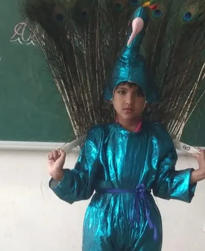 A student dressed as a peacock for the 'Show and Tell' competition, showcasing creativity and confidence while speaking about our national bird.