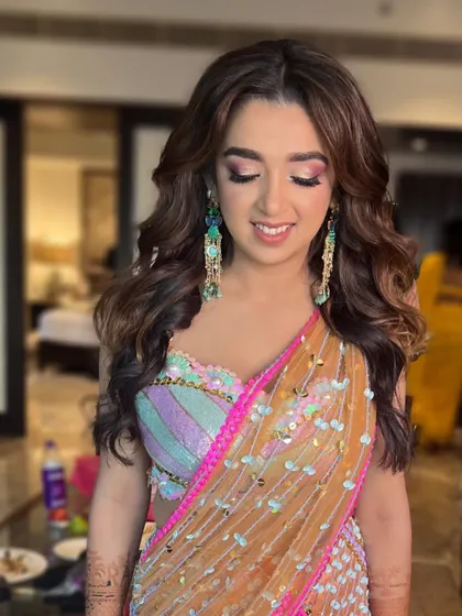 The soft waves and glowing skin complete this stunning Mehendi look. The makeup is designed to look beautiful both in person and in photos.
