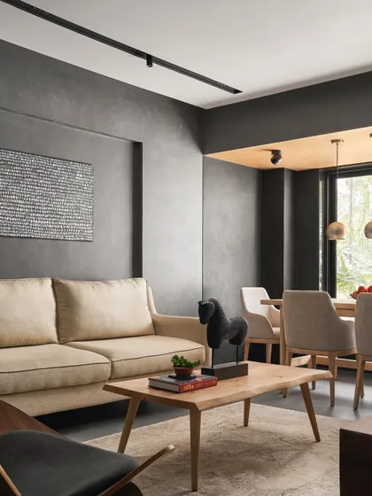 The living and dining space in AD House uses a darker concrete finish for a moodier, more intimate feel. The warmth of the ash wood dining table and chairs provides a necessary balance.
