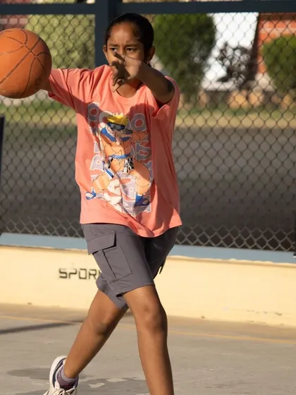 A young player confidently executes a pass during a practice session. We teach our students not just individual skills but also how to play together as a team, focusing on court awareness and communication.