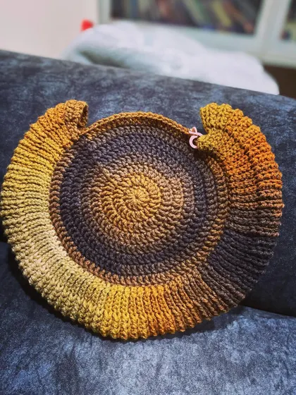 A work in progress! This is the base of a round bag made with a gorgeous gradient yarn that shifts from dark brown to golden yellow.