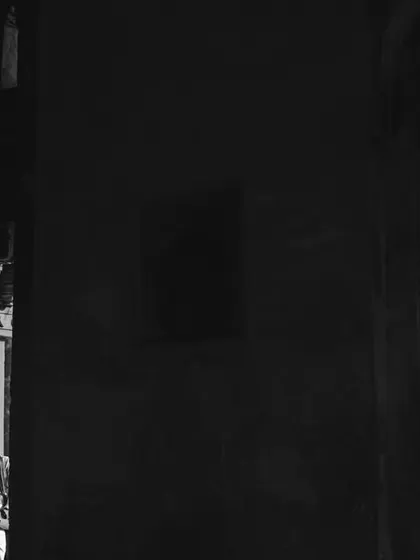 A dramatic black and white photo using light and shadow to create a sense of mystery and romance within a historic Delhi location. This is an example of our moody, artistic couple photography.