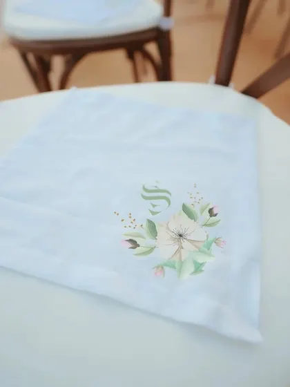 A custom-printed napkin with the couple's monogram, one of the many personalized details we handle.