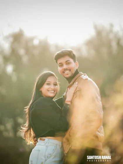 A sun-flared portrait that gives a warm, dreamy feel to this couple's outdoor photo.