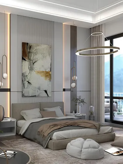This spacious bedroom feels like a luxury hotel suite, with its large window, comfortable seating area, and modern art. The neutral color palette is calming and sophisticated.