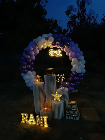 This is a more atmospheric view of the outdoor 'Bride to be' setup, captured just as night falls. The glow from the neon sign, marquee letters, and decorative stars creates a captivating and intimate feel for a special evening celebration.