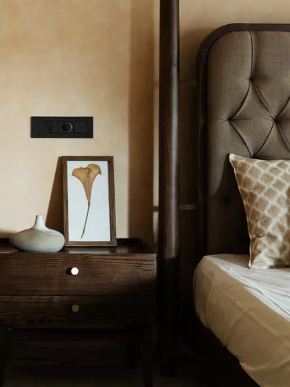 A close-up of the exquisite craftsmanship of my bedroom furniture. The deep-button tufting on the headboard and the rich grain of the wooden bedside table showcase my attention to detail and quality.