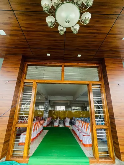 The entrance to a beautifully prepared wedding hall in Chitradurga. We coordinate our setup to match the venue's aesthetic, creating a seamless experience.