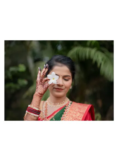 A creative portrait of the bride-to-be holding a white flower over her eye, a simple yet beautiful shot from her engagement session.
