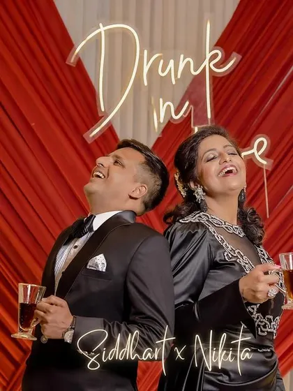 "Drunk in Love" says it all. A fun and playful shot of the couple laughing back-to-back in front of a neon sign at their reception.