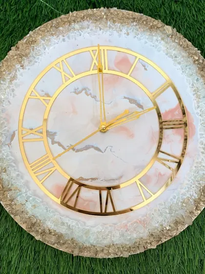 This clock features a soft pink and white marble design with a full border of sparkling gold and white crystals.