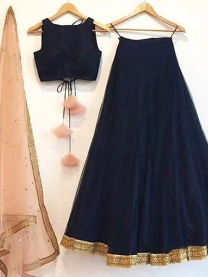 A classic navy blue lehenga set with a sleeveless blouse and a contrasting peach net dupatta. The simple gold border and playful tassels make this a versatile outfit for many occasions.