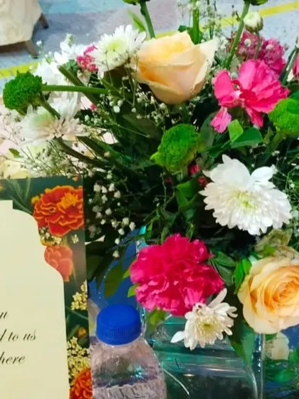 A close-up of a table centerpiece with a "Thank You" note for the guests. These small, thoughtful details, like fresh floral arrangements on each table, elevate the guest experience.