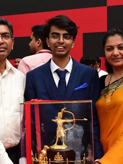 A portrait of our shooter Srijay with his parents and the Ekalavya Award. Family support is a cornerstone of our athletes' success.