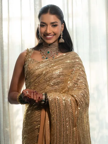 Radiance, redefined. Our client looks effortlessly elegant in a golden Manish Malhotra saree, her soft glam makeup enhancing her beautiful smile.