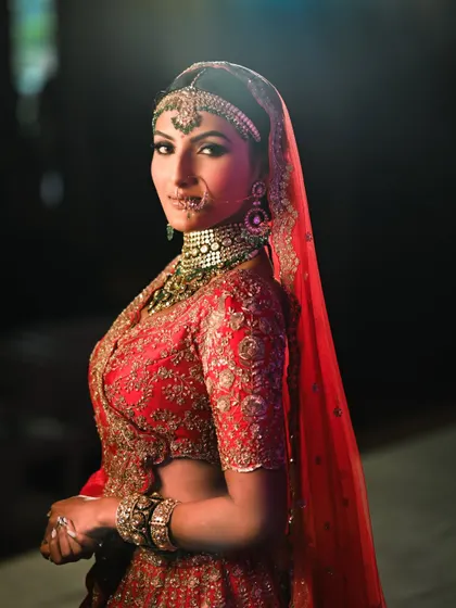 A regal bridal look with a dramatic, dark smokey eye and heavy jewelry. This demonstrates the high-impact, glamorous makeup you will learn to create for grand weddings.