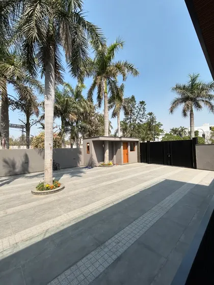 The driveway at Gulmohar Farmhouse was designed to accommodate several mature palm trees. By paving around them, we preserved the site's established greenery and created a grand, tree-lined entrance.