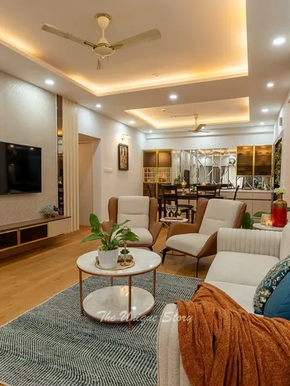 This view showcases the textured wallpaper and bronze mirror strips flanking the TV unit. These details add a layer of sophistication and visual interest, reflecting light and making the living space feel more dynamic and luxurious.