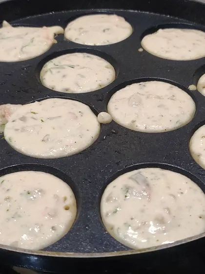 The cooking process of our appe, showcasing the fresh batter before it's flipped to cook on the other side.
