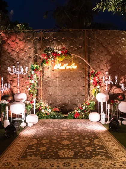A beautiful floral arch with a custom neon sign, creating a personalized and romantic photo backdrop.