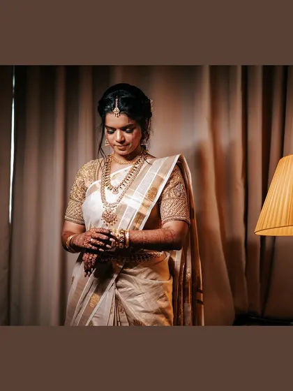 A full-length portrait of the bride in a softly lit room. The composition and lighting give this photo a very classic and elegant feel.