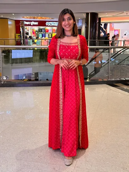 A stunning red gown-style Anarkali with a matching jacket. This outfit is perfect for a grand occasion like a wedding reception or a big Diwali party.