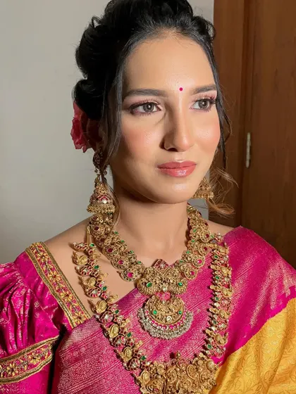 This close-up shot showcases the soft pink eyeshadow and glossy lip that completed her look. It's a fresh and modern take on traditional bridal makeup.