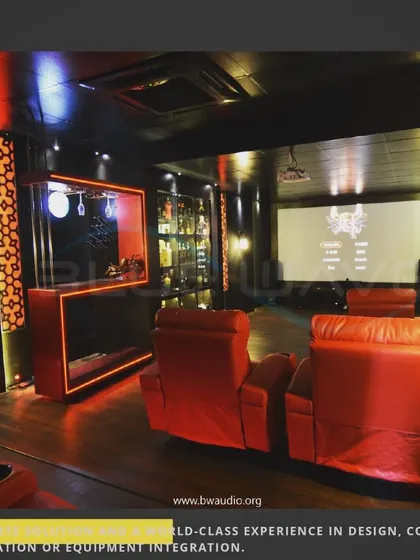 This project features a custom-designed bar and display cabinet integrated directly into the home theater. The red LED lighting connects the two spaces, creating a cohesive and stylish entertainment zone.